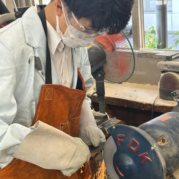 A Futsubu student grinding knife material (steel) in the technology room