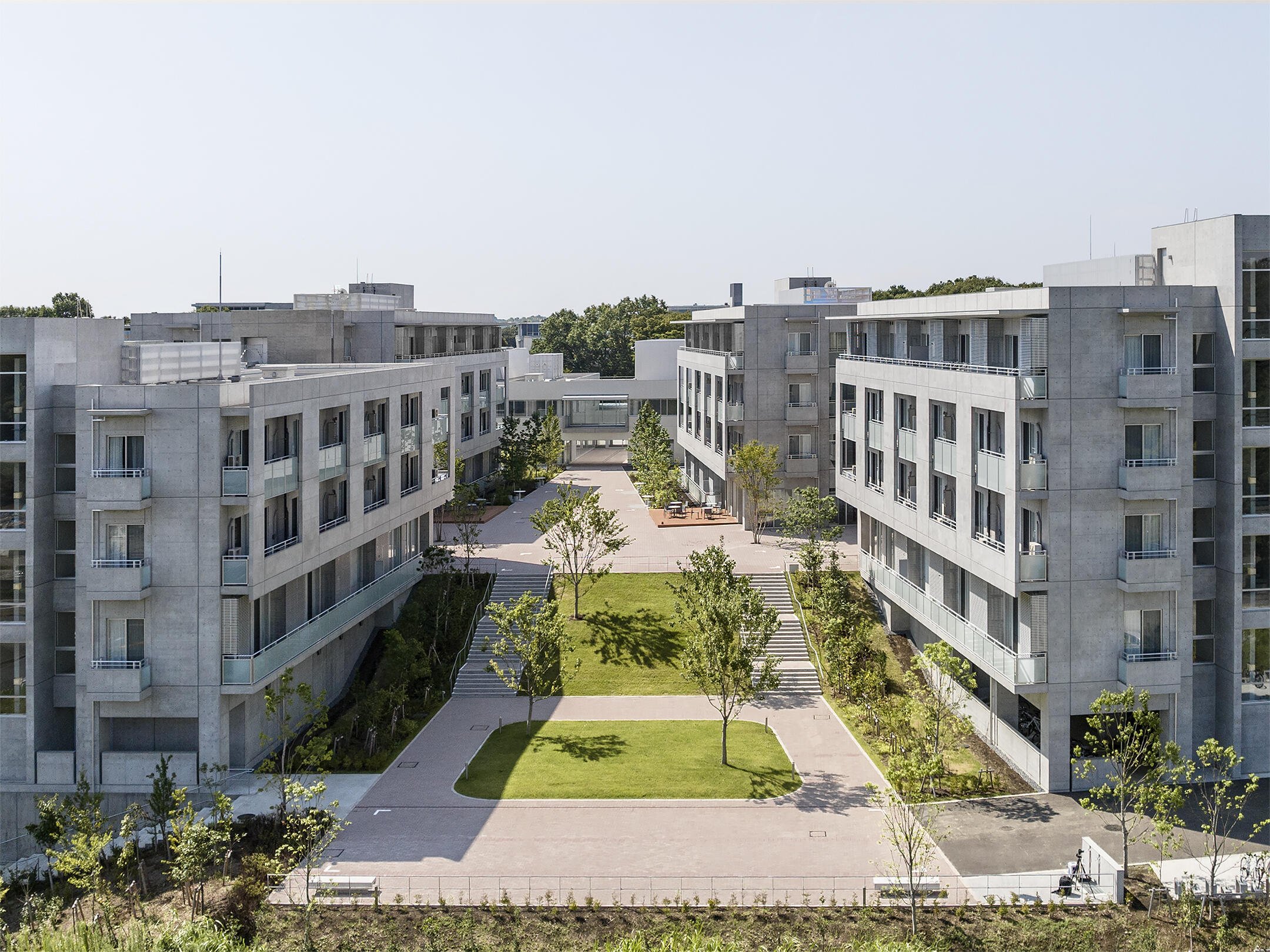 An aerial view of a modern residential complex with a central courtyard and symmetry.