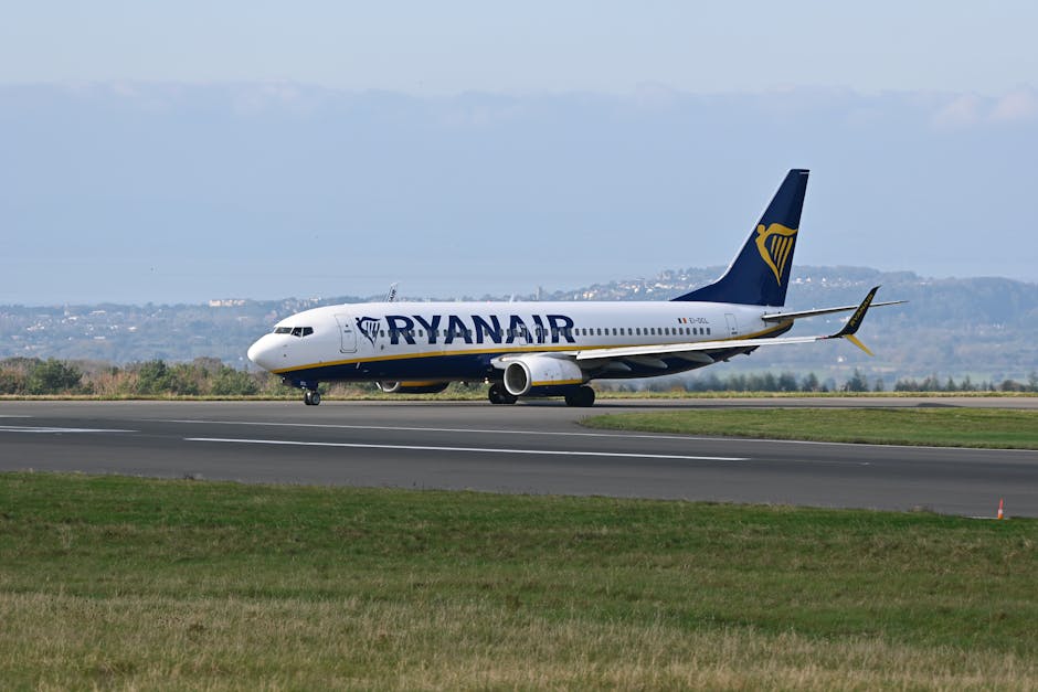 A Ryanair aircraft on the runway preparing for takeoff with a scenic backdrop of distant hills and clear skies.