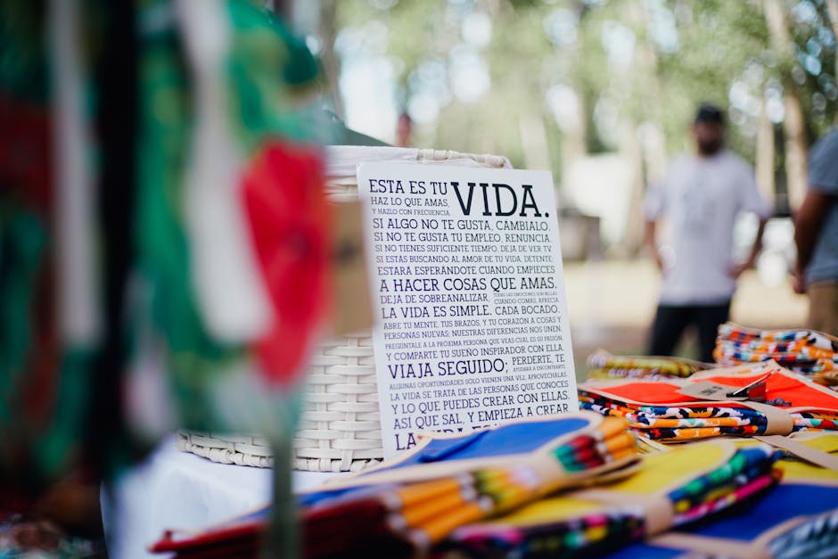 Vibrant market scene featuring colorful fabrics and an inspirational sign in Spanish.