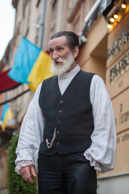 Senior man in traditional attire stands on a vibrant street in Lviv, Ukraine, with flags in the background.