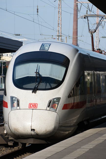 A sleek high-speed train at an urban station platform, ready for departure.