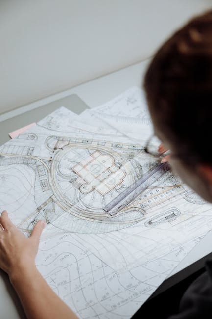 Professional architect analyzing detailed blueprints at a workplace.