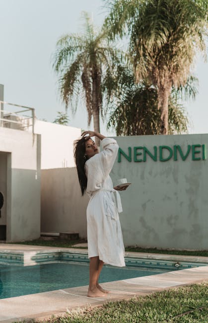 A serene outdoor scene featuring a woman in a bathrobe by a swimming pool, embracing a tranquil moment.