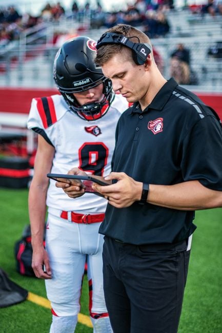 coach analyzing AI tablet pitchside football tactical tablet analysis