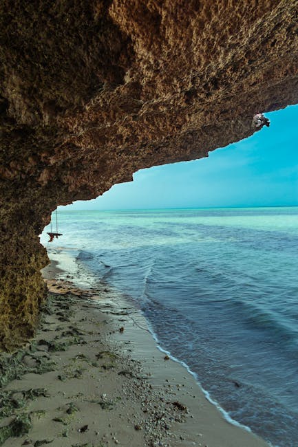 Discover the scenic beauty of a sandy beach with a cave in Jazan, Saudi Arabia, perfect for travel explorations.