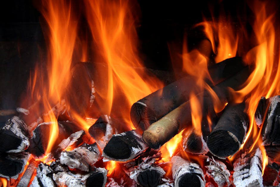 A vibrant image of burning wood with glowing embers and bright flames.