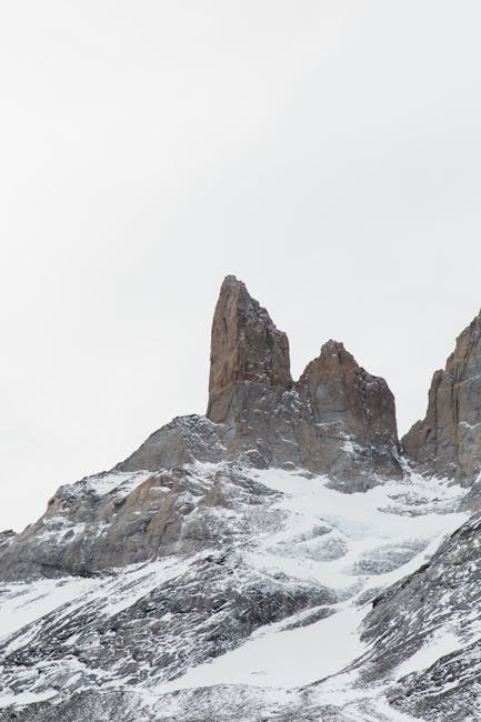 Majestic snow-covered rocky peaks in the Patagonian landscape during winter, showcasing nature's rugged beauty.