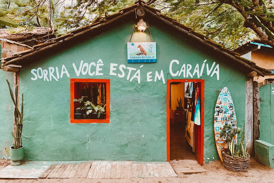 Green facade with surfboard and text 'Smile You Are in Caraíva' at a cozy eatery.