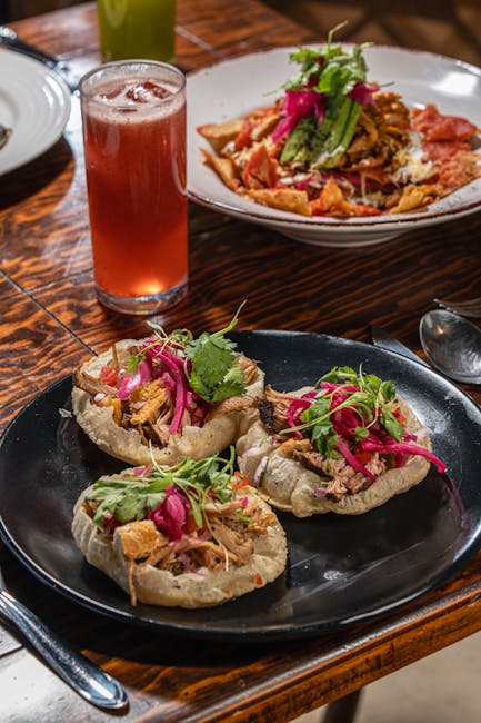 Tasty Mexican sopes topped with meat and veggies served alongside chilaquiles and a refreshing drink.