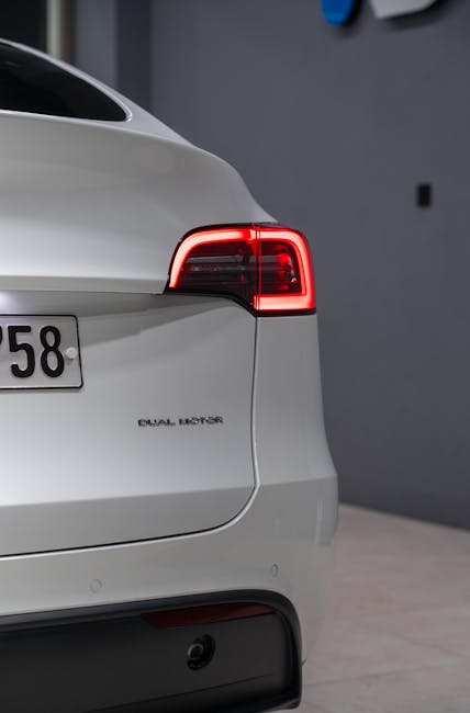 A sleek, modern white electric car with illuminated tail lights, emphasizing eco-friendly technology.