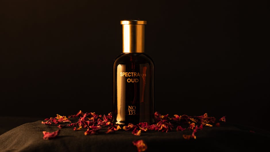 Elegant oud perfume bottle surrounded by rose petals on a dark backdrop, exuding luxury.