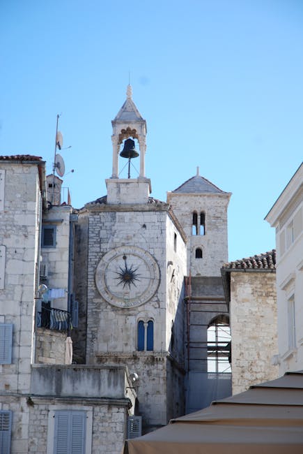 A classic view of a historic clock tower in Split, Croatia, under clear blue skies.