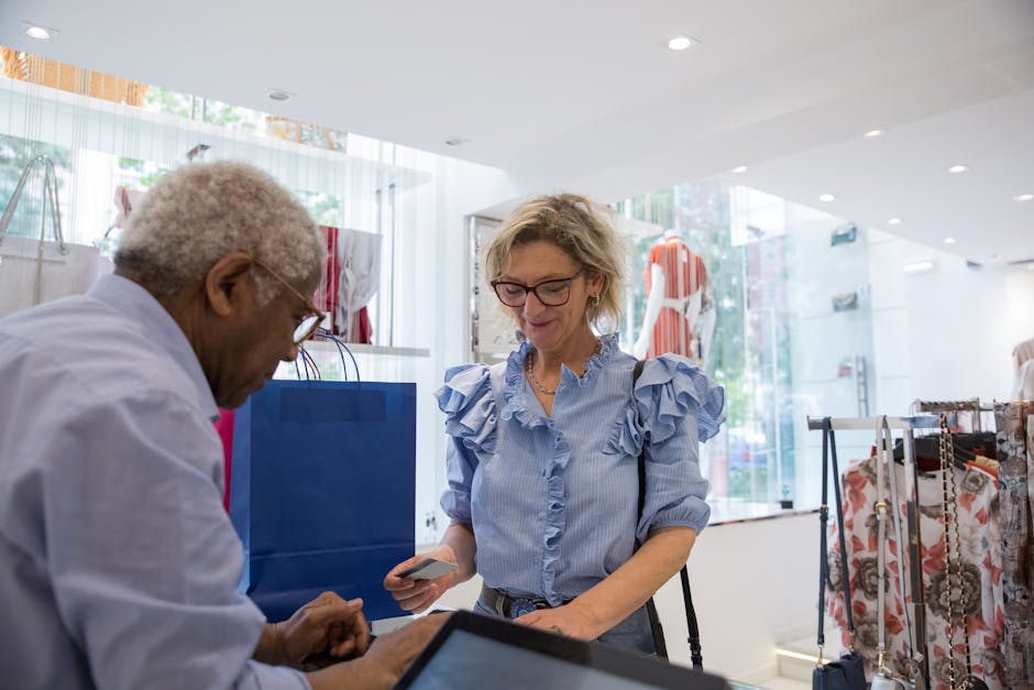 Elegant seniors making a cashless payment in a stylish clothing store. A moment of modern shopping.