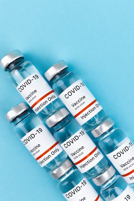 Top view of COVID-19 vaccine vials arranged on a blue surface.