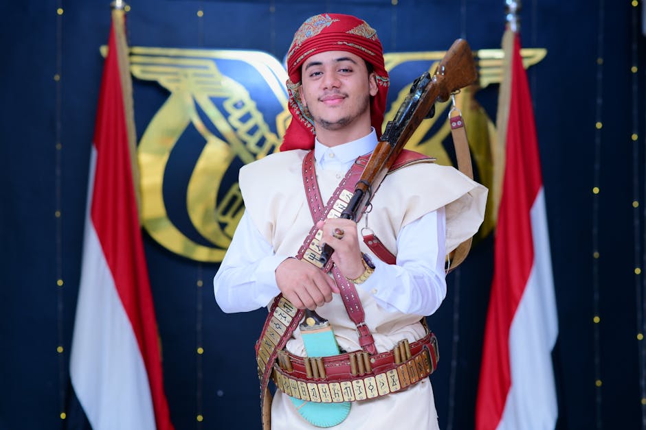 A man dressed in traditional Yemeni attire participates in a ceremonial event holding a rifle.