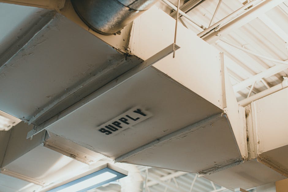 commercial HVAC technician inspecting ventilation ducts building