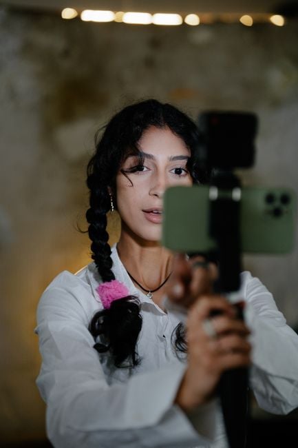 female creators filming football players social media pitch short video