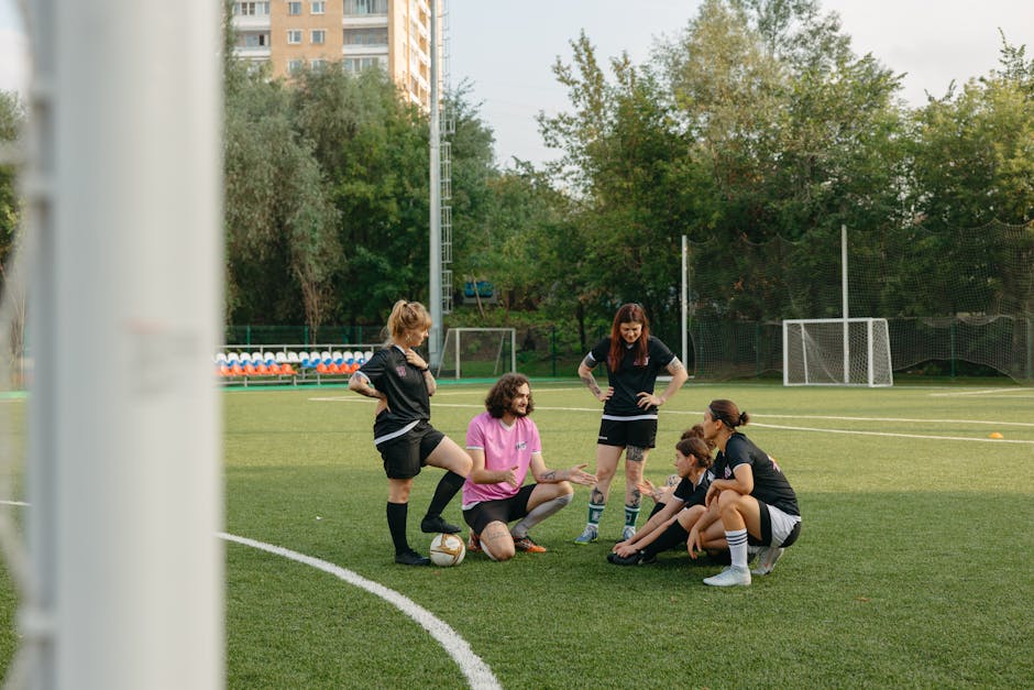coach analyzing soccer video laptop field team discussion