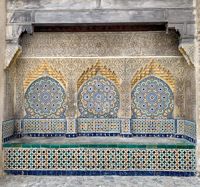 A detailed view of ornate Moroccan mosaic tiles with geometric patterns and carvings.