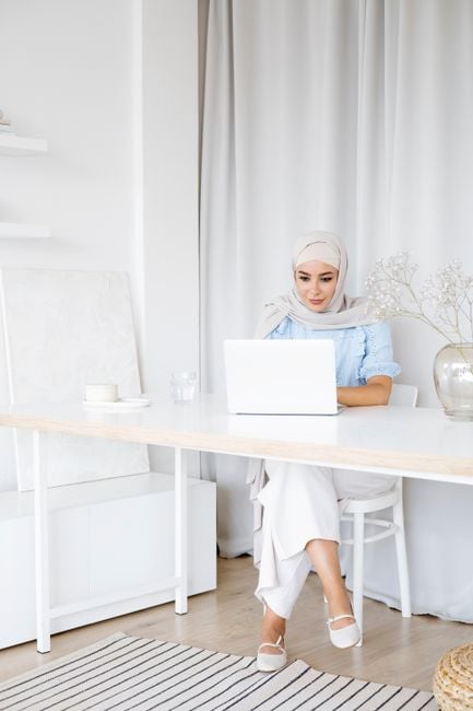 Arab remote worker laptop AI assistant tidy workspace