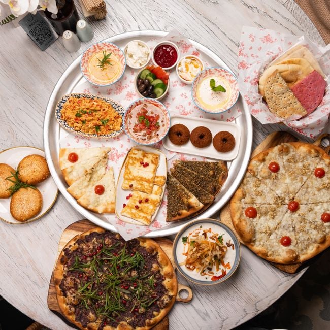 Delicious Middle Eastern mezze platter with variety of dishes including manakish and dips, perfect for sharing.