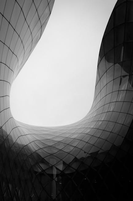 Black and white photo of abstract modern architecture in Malmö, showcasing elegant curves and glass surfaces.