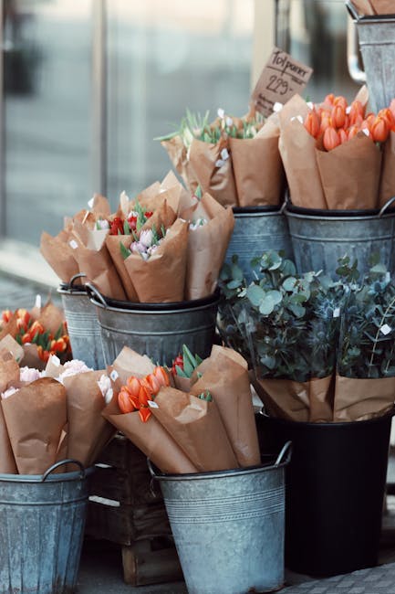 Brightly colored flower bunches displayed in metal buckets at Gothenburg outdoor market.
