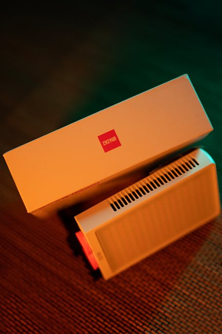 Overhead view of a sleek electronic device with stylish packaging, illuminated by warm lighting.