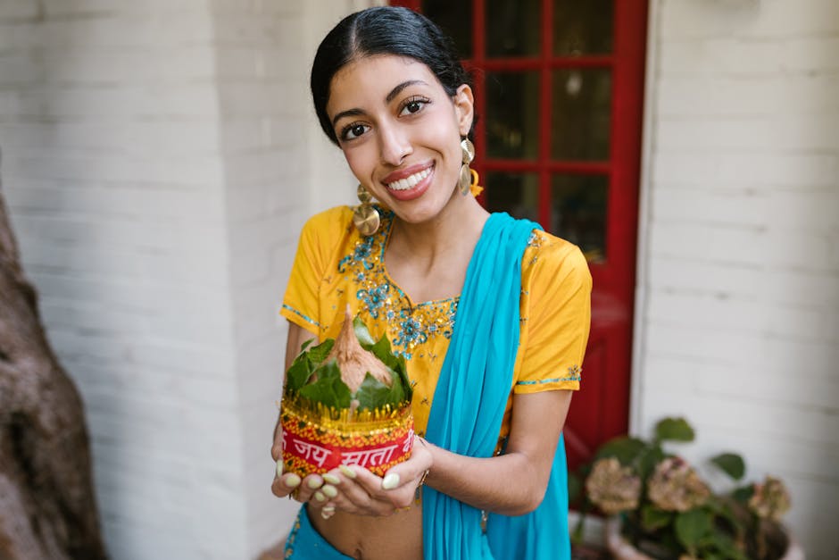 A joyful woman in vibrant traditional attire holding festive decorations during a celebration.