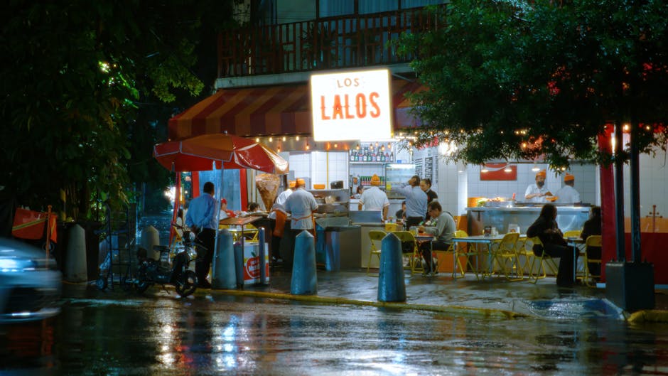 Capture of Los Lalos street restaurant bustling with activity at night in Mexico City.