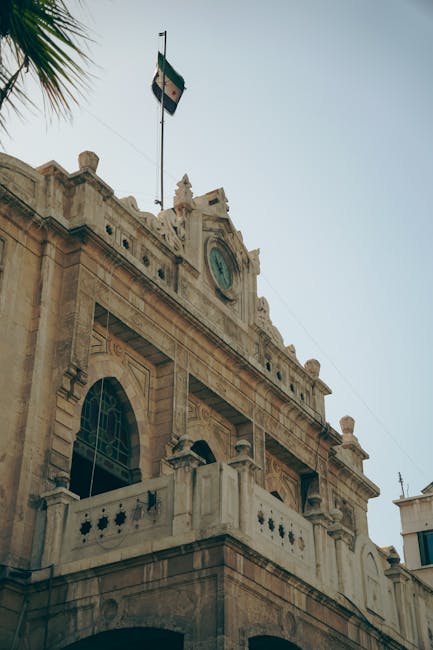 Capture of a historic building in Damascus, featuring unique Syrian architecture and a national flag.