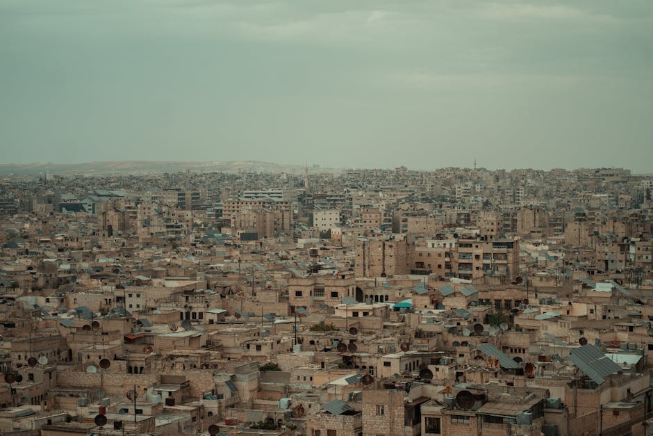 A wide aerial view of the densely packed urban landscape of Aleppo, Syria.