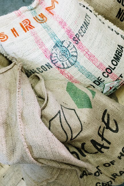 Close-up of burlap sacks for organic coffee beans in a roastery setting.