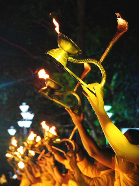 A vibrant spiritual ceremony with raised flaming torches in Kolkata, India.