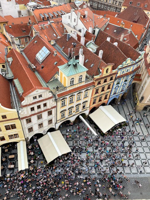 Drone shot of a busy market square with colorful rooftops and crowds in Europe.