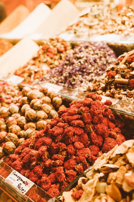Colorful assortment of dried fruits and spices in a bustling market stall.