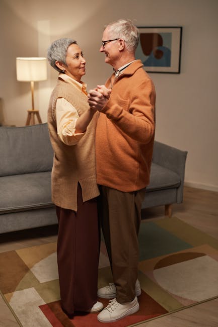 A senior couple enjoys a romantic dance in their cozy living room, embracing love and joy.