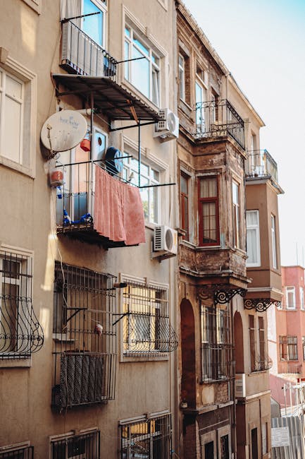 Charming apartment building exterior capturing balconies, air conditioners, and architectural details in daylight.