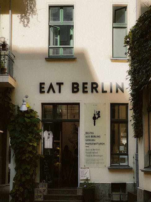 Charming urban restaurant facade in Berlin featuring lush greenery and inviting entrance.