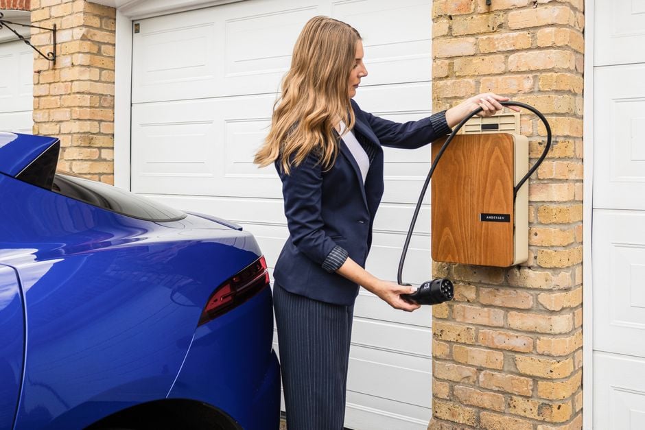 A woman uses a home charging station to charge her electric car, highlighting eco-friendly lifestyle choices.