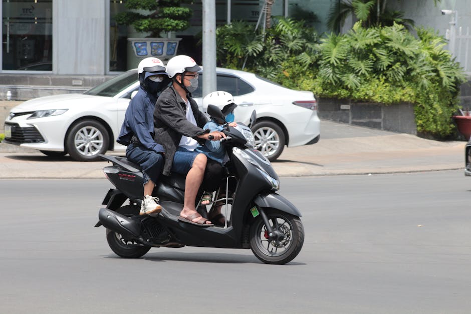 A family of three rides a scooter on a sunny day in Nha Trang, Vietnam.