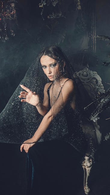 A mysterious portrait of a woman draped in a dark, sparkling veil creating a dramatic mood.