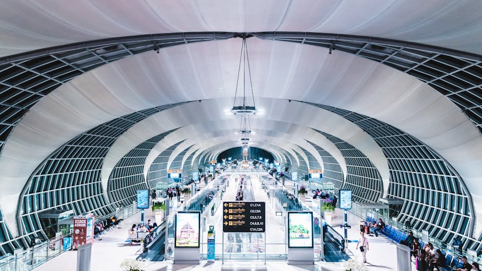 Modern airport terminal interior with futuristic design, showcasing glass and steel structures.