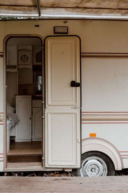 White mobile home with open door, revealing rustic interior charm.