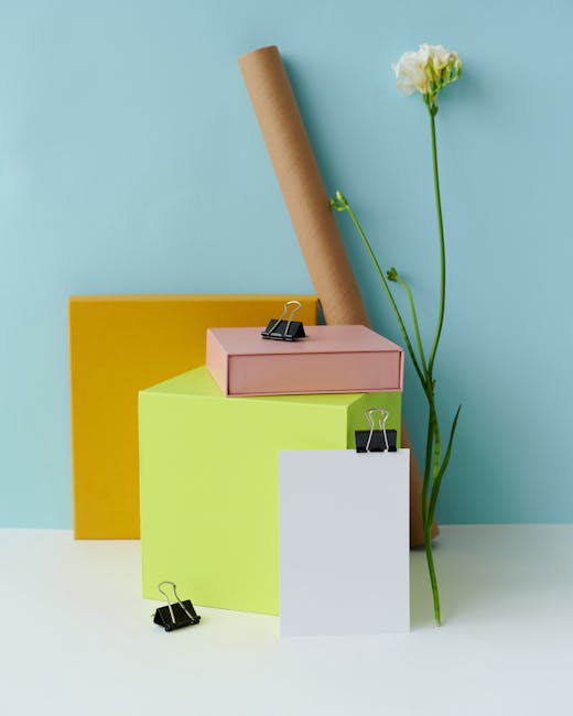 Stacked colored boxes, paper clips, and flowers create a vibrant stationery mockup.