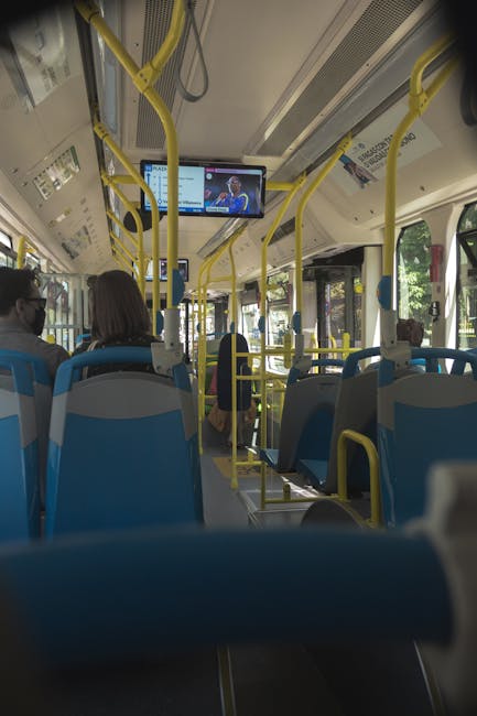 A perspective shot capturing commuters aboard a modern city bus with digital screens.