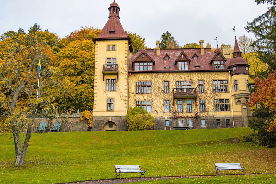 A picturesque historic building in Huskvarna, Sweden, set against vibrant autumn leaves.