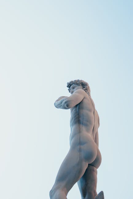 Low angle view of Michelangelo's David statue in Florence, Italy, under a clear sky.