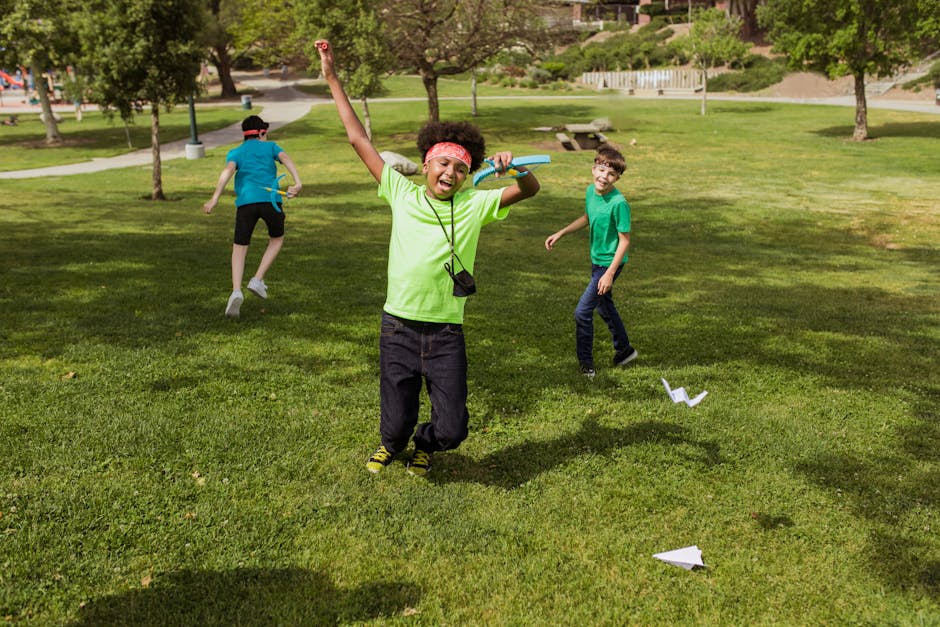 Kids having fun outdoors at summer camp playing with paper airplanes.